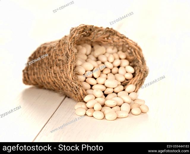 Close up white beans on white wooden table. Macro shoot with selective focus. Shallow DOF