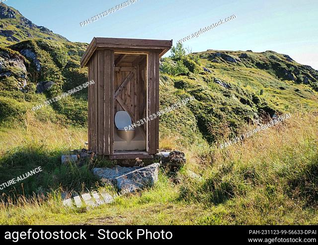 26 August 2023, Norway, Leknes: A wooden toilet hut without a door stands off the trail in the mountains near Leknes during a hike