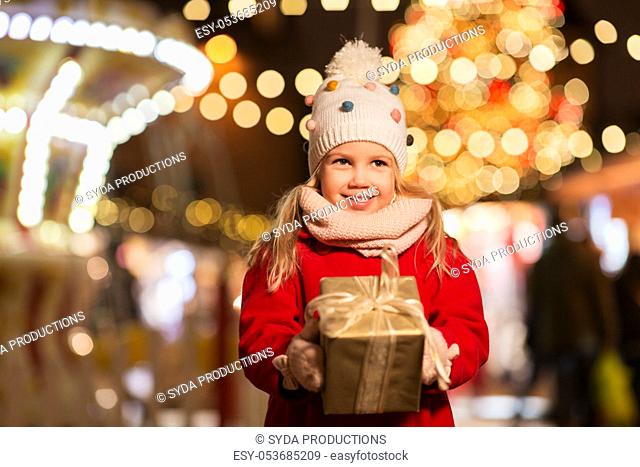 happy girl with gift box at christmas market