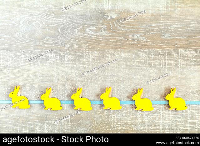 Easter accessories on a light wooden surface. Yellow orange easter concept, top view, copy space, in yellow tones on a wooden surface