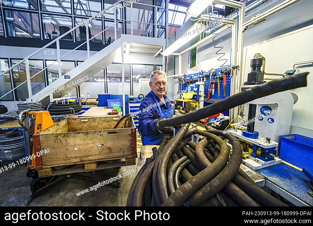 PRODUCTION - 06 September 2023, Hesse, Fulda: An employee puts down a rubber hose at his workplace in the DB Fahrzeuginstandhaltung plant