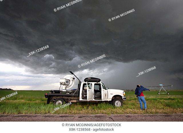 Storm chaser and scientist Robin Tanamachi stands next to a doppler radar truck that she is operating for Project Vortex 2