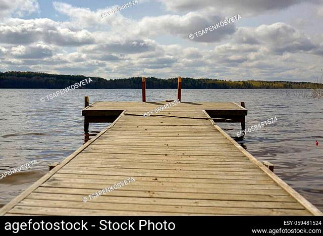 Southern Karelia, Finland. Wooden dock near the waterside with cloudy sky in background. Lake Saimaa