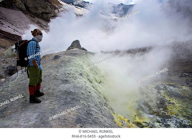 Tourists standing by smoking fumaroles on Mutnovsky volcano, Kamchatka, Russia, Eurasia