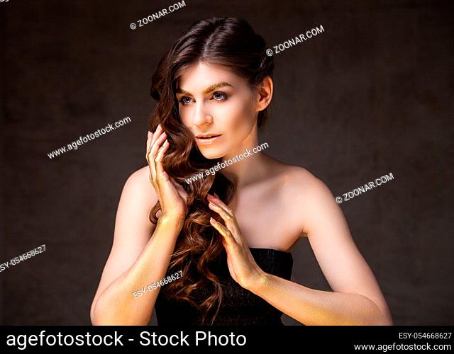 Portrait of attractive young brunette touching beautiful brunette hair