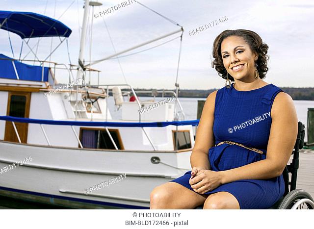 Disabled woman smiling in wheelchair on harbor