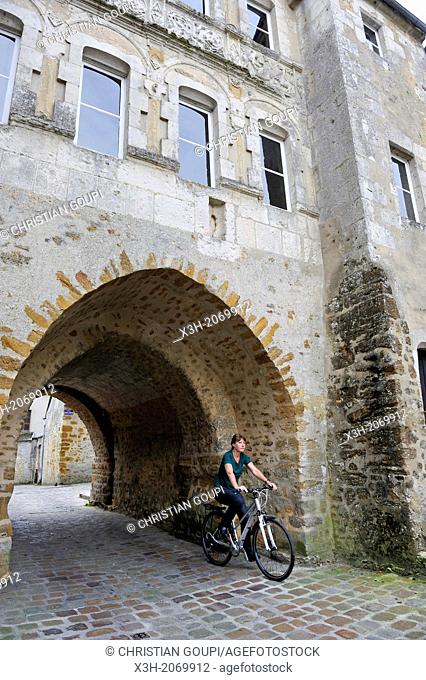 young woman cycling under the Saint-Denis Gate, Mortagne-au-Perche, Regional Natural Park of Perche, Orne department, Lower Normandy region, France