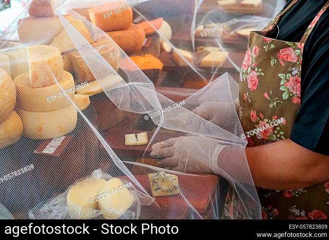Vendor serving variety of traditional cheese in a cheese farm store, Fazenda Atalaia Cheese Farm, Amparo, State of Sao Paulo, Brazil