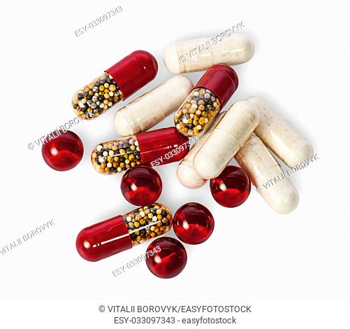 Scattered pills and capsules different color isolated on white background