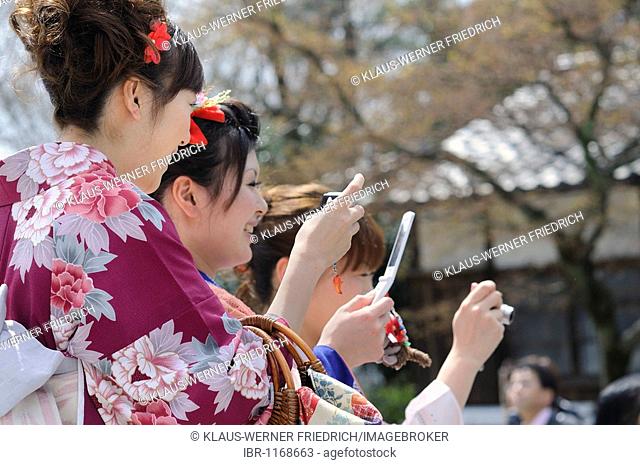 Young women in kimonos and with mobile phones in the old town, Kyoto, Japan, Asia