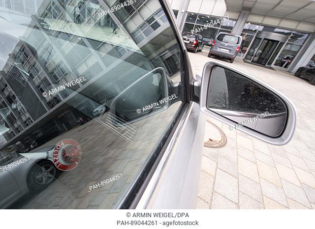 A police sign reflected in a car window of an undercover police car in front the corporate management of Audi AG, as seen on 15 March 2017 in Ingolstadt