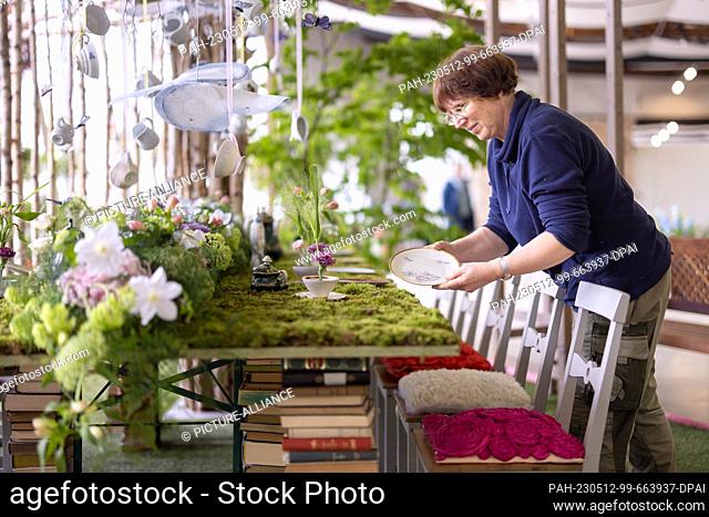 12 May 2023, Thuringia, Erfurt: Master florist Cornelia Squara decorates the ""Mad Hatter's Tea Table"" in the summer indoor show ""Welcome to egapark...