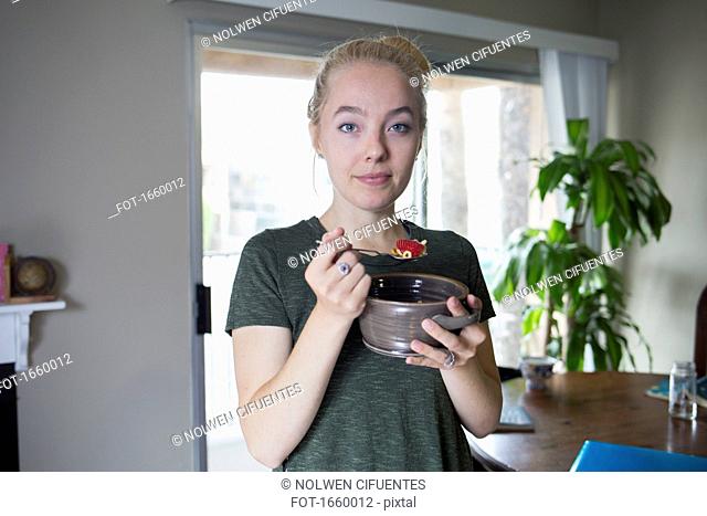 Portrait of woman eating breakfast at home