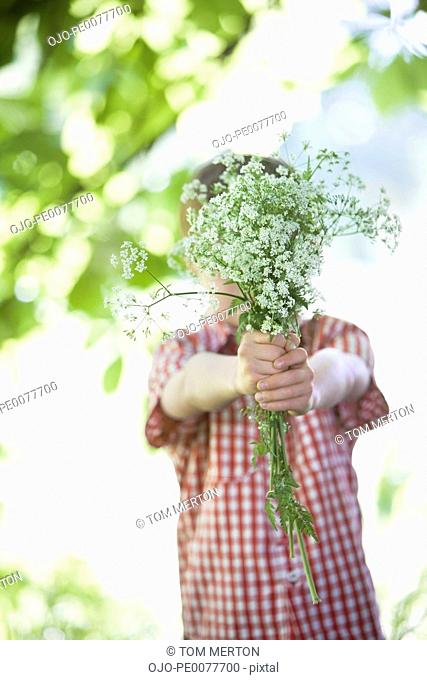 Boy offering bouquet of flowers