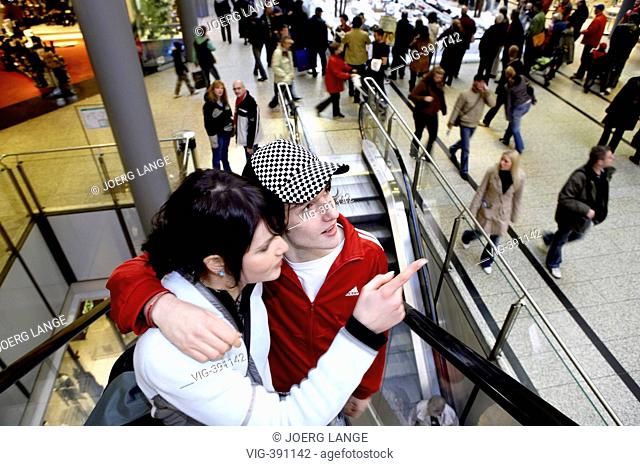 A young couple is standing in a shopping centre with Christmas decoration. - Berlin, GERMANY, 02/12/2006