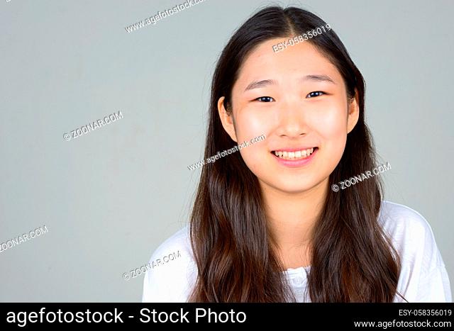 Studio shot of young beautiful Korean woman against white background