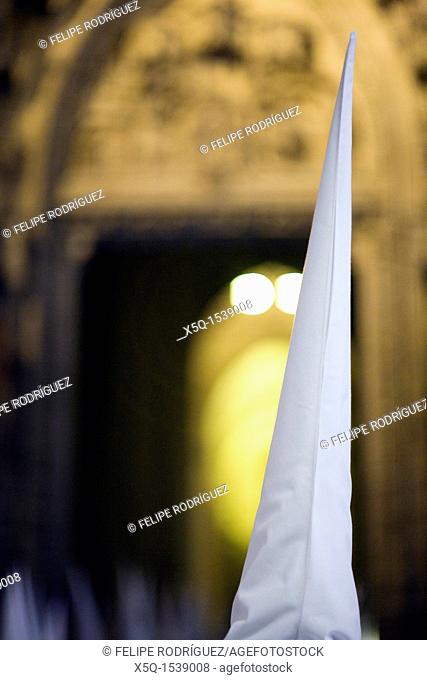 Hooded penitent entering Seville's cathedral, Holy Week, Spain