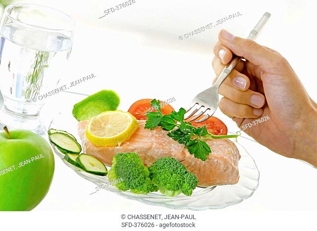 Salmon fillet with vegetables, a glass of water & an apple