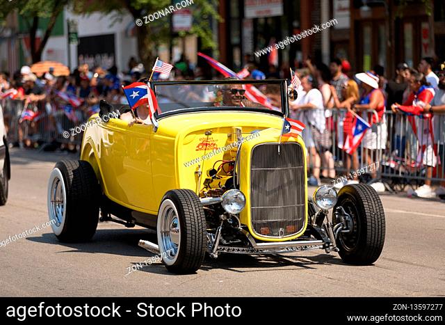 Chicago, Illinois, USA - June 16, 2018: The Puerto Rican People's Parade, Puerton rican people riding on cars celebrating with puerto rican flags