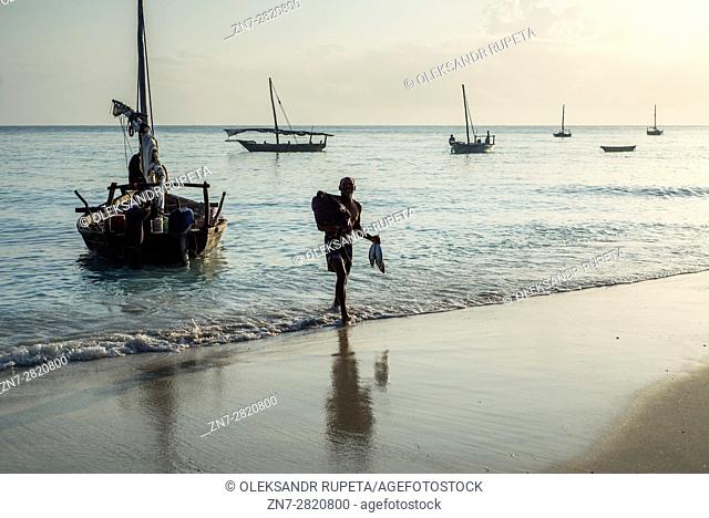 Fishermen carry their catch, the yellowfin tuna, to the fish market near the ocean in Nungwi village, Zanzibar. Dealers are ready to bargain for fish during the...