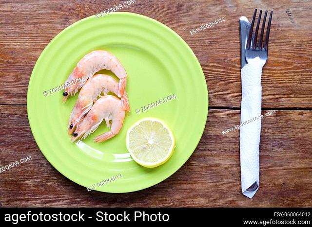 shrimps portion on green plate with lemon slice