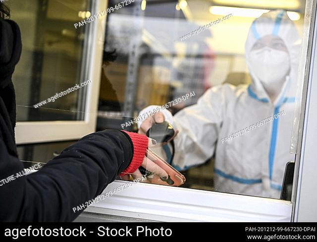 11 December 2020, Berlin: A young woman registers for a SARS-CoV-2 antigen test at the Corona Antigen Rapid Test Centre at Mauerpark in the Berlin district of...