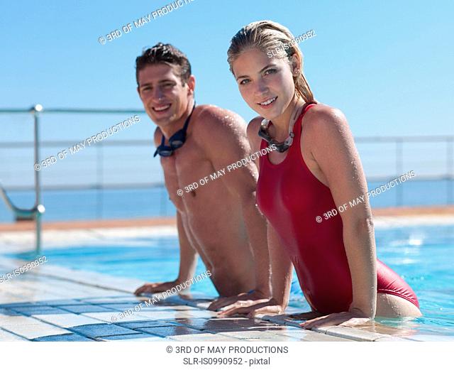 Young couple exiting swimming pool