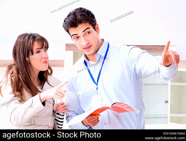 The salesman explaining to woman customer at furniture store