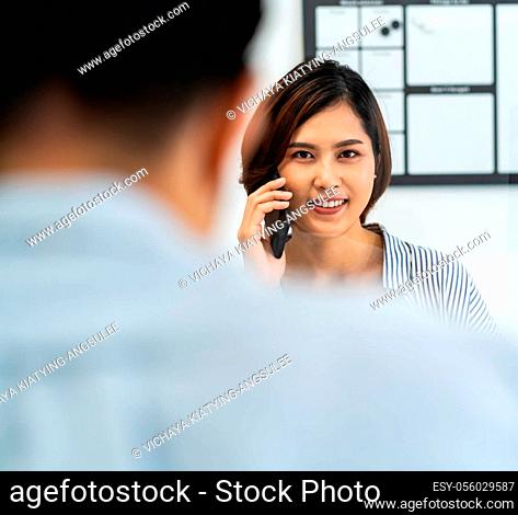 Businesswoman working and making a call in home office with social distance using screen partition to prevent from coronavirus COVID-19 spreading