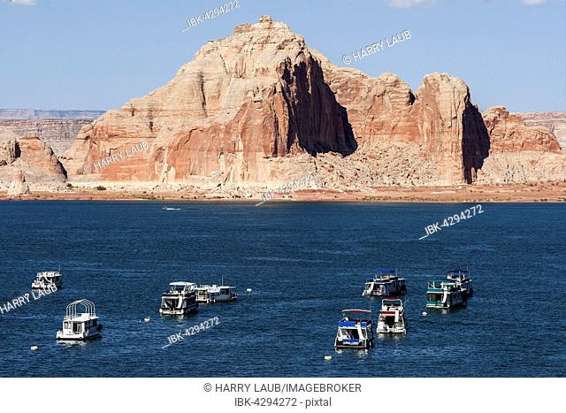Red Navajo Sandstone cliffs, Castle Rock, houseboats in Wahweap Bay, Lake Powell, Page, Arizona, USA