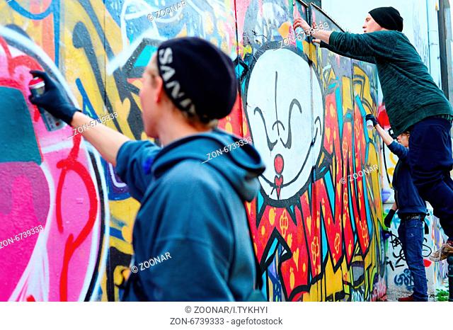 LISBON, PORTUGAL - DECEMBER 23, 2014: Boys painting graffiti on the wall in Lisbon.Along with London, Berlin, New York and others