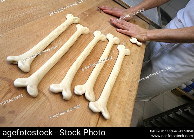 08 January 2020, Bavaria, Irsee: Gudrun Koneberg, master baker, forms lye pastries in the shape of bones in the bakery of her bakery