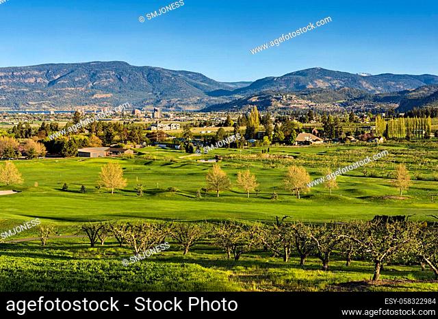 A golf course in the Okanagan Valley with the Kelowna British Columbia Canada skyline and Okanagan Lake in the background