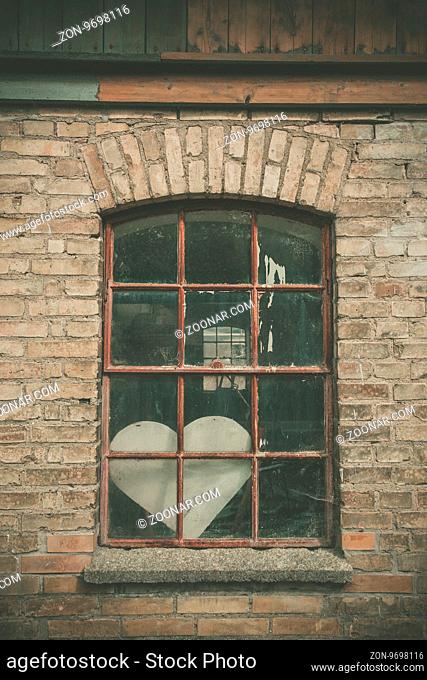 Forgotten love heart in a window on an old building