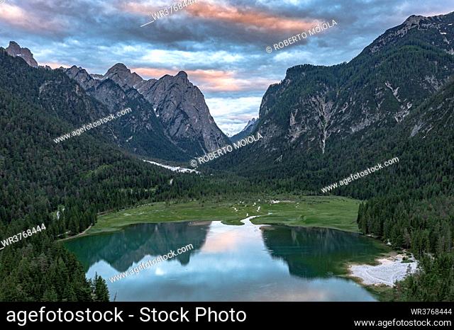 Aerial view of mountains reflected in lake Dobbiaco at sunset, Dobbiaco (Toblach), Dolomites, Bolzano province, South Tyrol, Italy, Europe