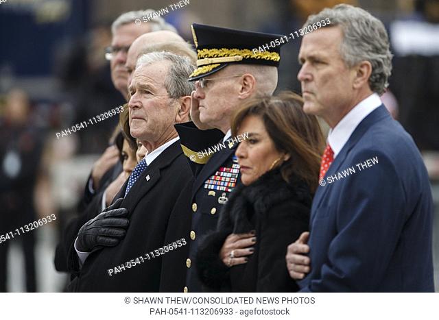 Former US President George W Bush and members of the Bush family watch as a joint service honor guard carries the casket of former US President George H