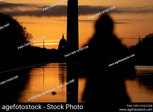 A person watches the sunrise from the Lincoln Memorial reflecting pool in Washington D.C., U.S. on Tuesday, March 23, 2021
