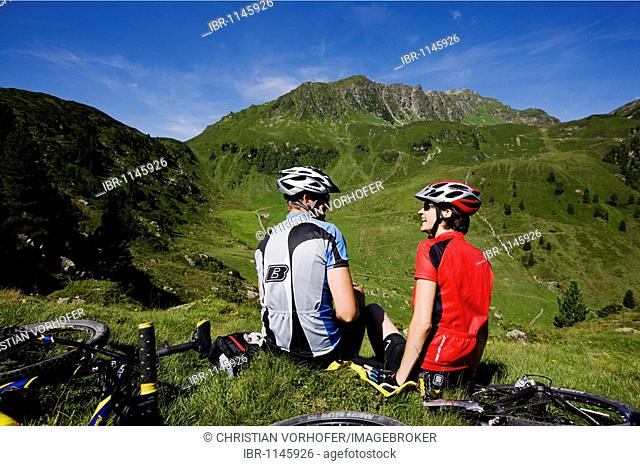 Mountain bikers having a break, Mt Galtenberg in the back, Kitzbuehl Alps, Alpbachtal, North Tyrol, Austria, Europe