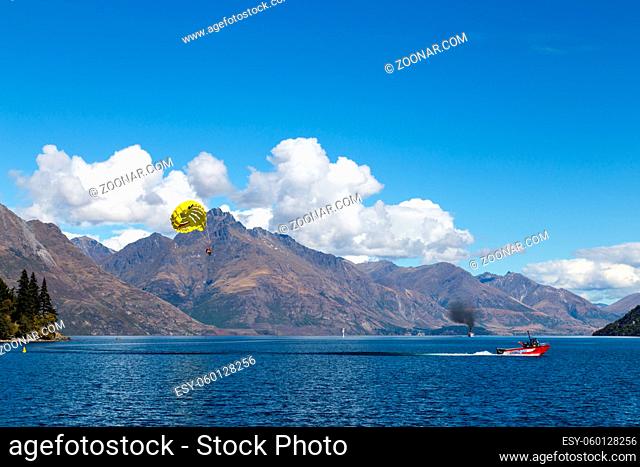 Queenstown, New Zealand - March 26, 2105: A parasailing boat on Lake Wakatipu as seen from Queenstown