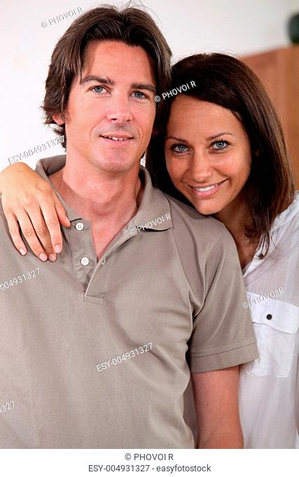 a 35 years old woman putting her arm around her husband