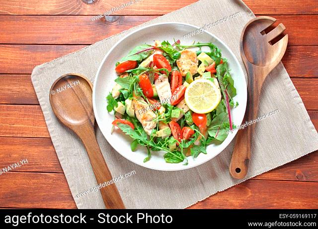 Chicken salad with avocado and cherry tomatoes, arugula and beet leaves