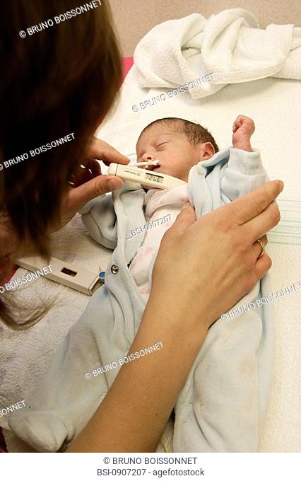 Photo essay at the hospital of Meaux 77, France. Department of neonatology. A mother is measuring the temperature of her premature child feeded by stomach tube