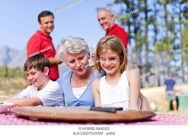 Woman with grandchildren at picnic table