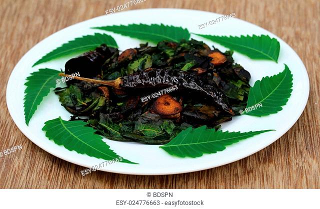 Fried neem leaves with on a white plate