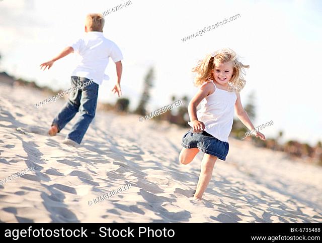 Adorable brother and sister having fun at the beach one sunny afternoon