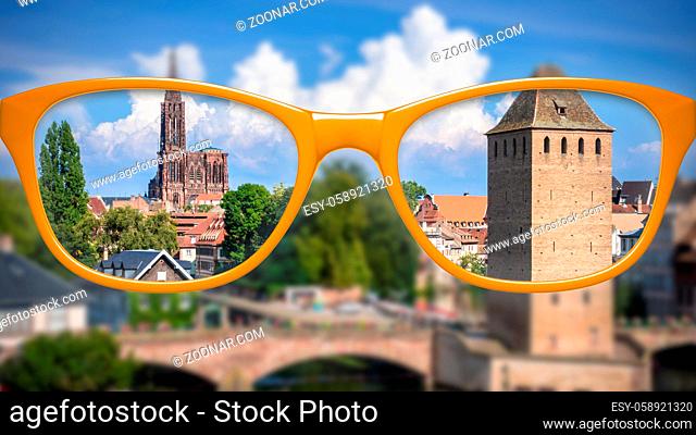 An image of orange glasses sharp and blurred Strasbourg scenery