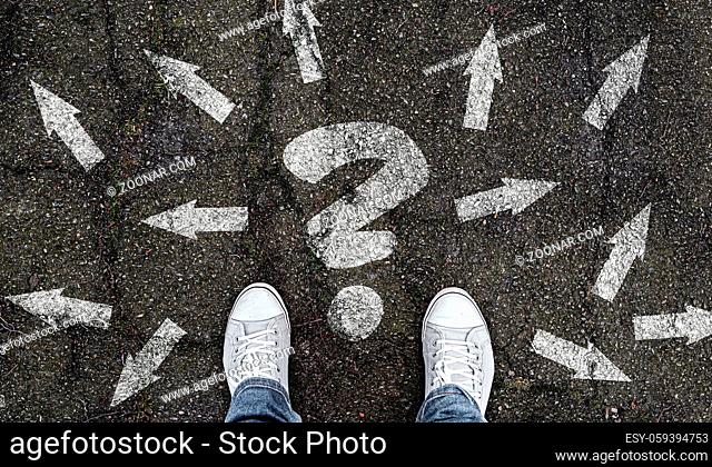 person standing on road with question mark and arrow markings pointing in different directions, decision making concept