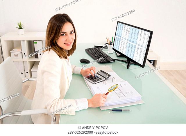 Happy Young Businesswoman Checking Invoice With Magnifying Glass