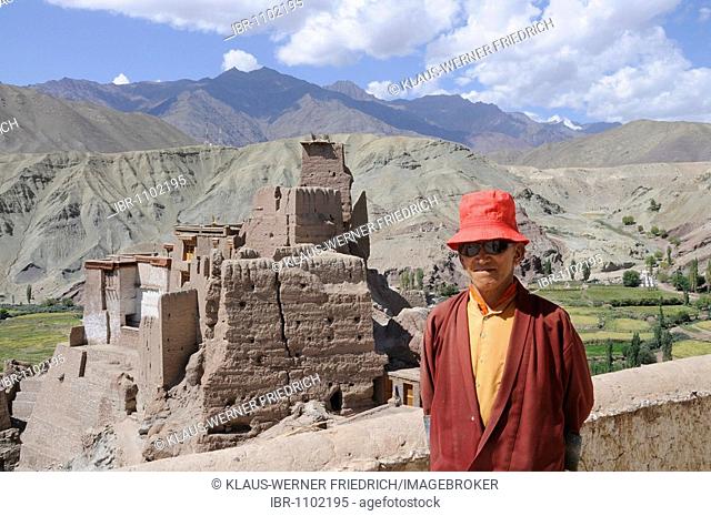 Buddhist monk in front of the Basgo castle ruins and monastery in the Indus Valley, Ladakh, India, Himalayas, Asia