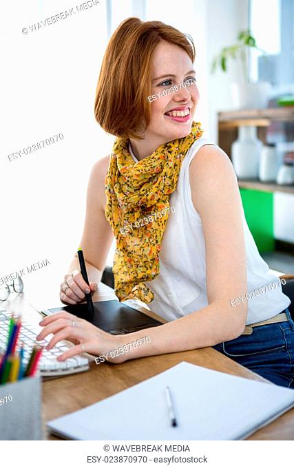 smiling hipster businesswoman writing on a digital drawing tablet